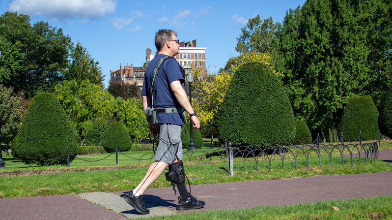 A man with a medical device on his leg walking
