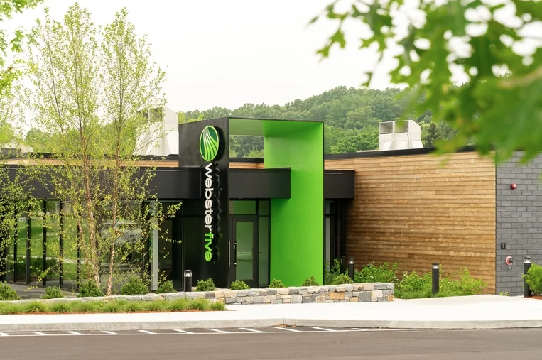 A small building with a green facade surrounding the door