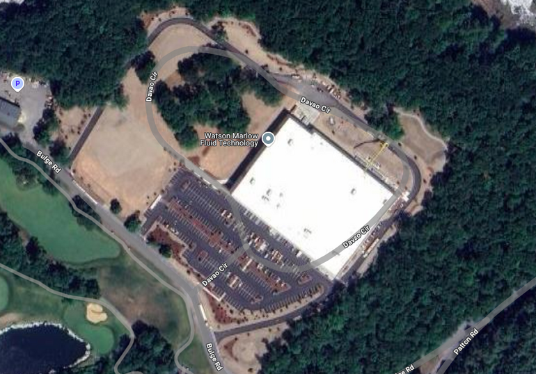 A satellite image of a manufacturing plant next to a golf course
