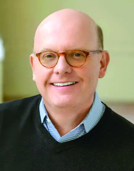 A man with glasses in a sweater