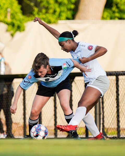 Two women battle for a soccer ball