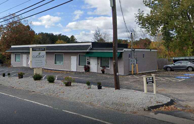 A small one-story building with a parking lot in front