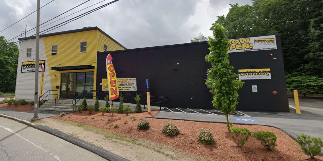 A small retail building painted white, yellow, and black