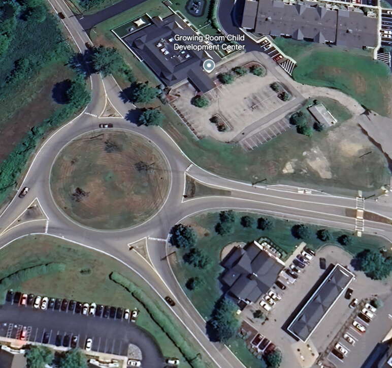 Satellite image of a traffic rotary with a gas station property in the lower right and a daycare property at top