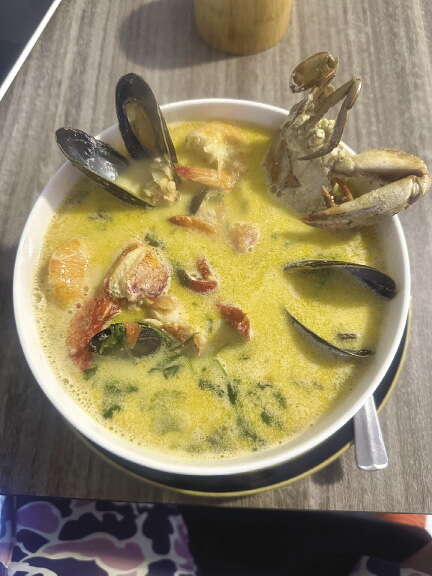 A bowl of soup with crabs and clams