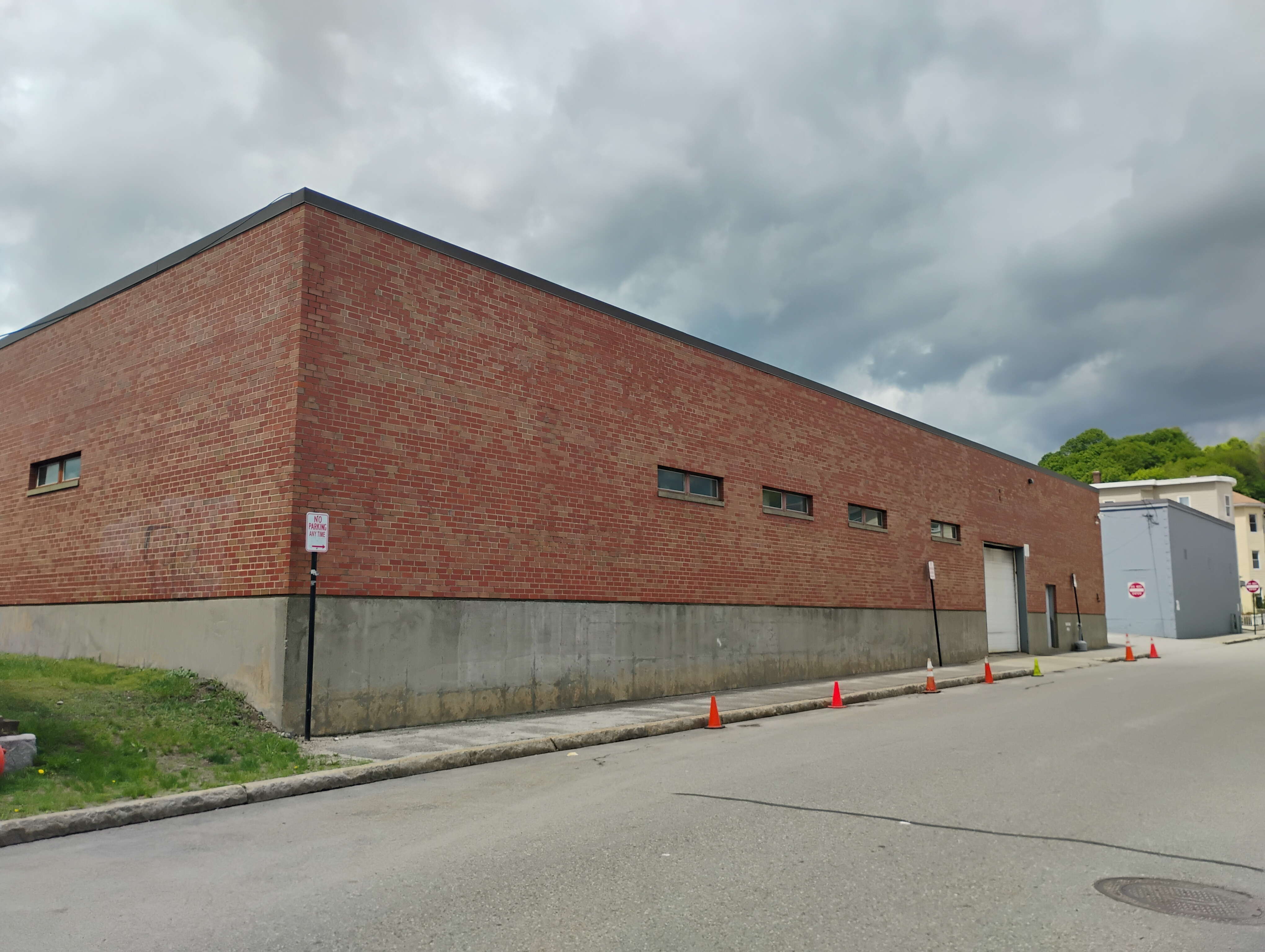 A brick warehouse building sits behind an empty street