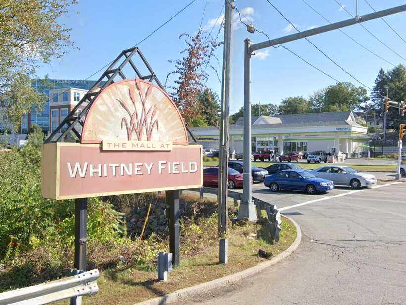 A sign advertising a mall on the side of a road