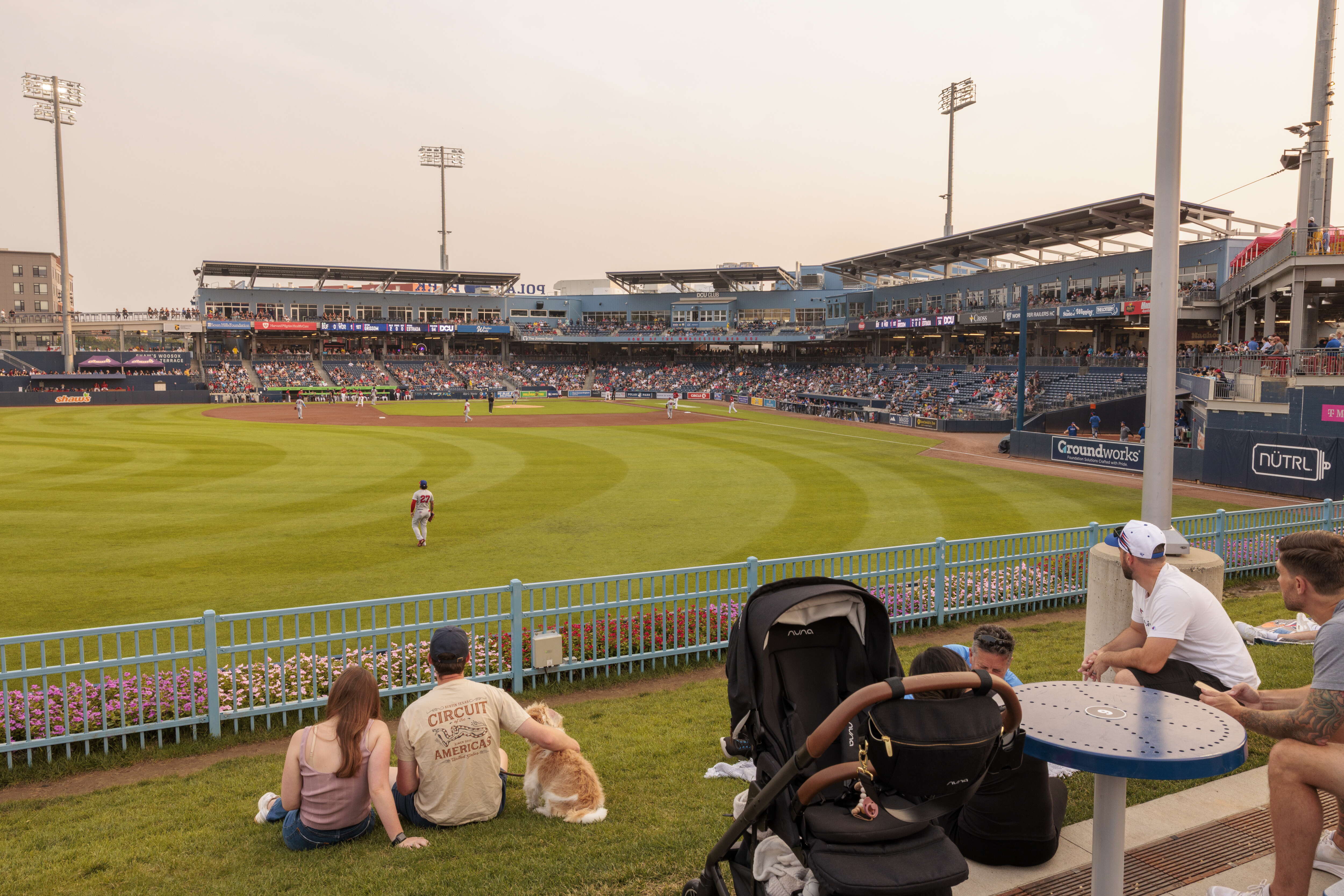 A minor league stadium from a been in left field, showing the main stands. 