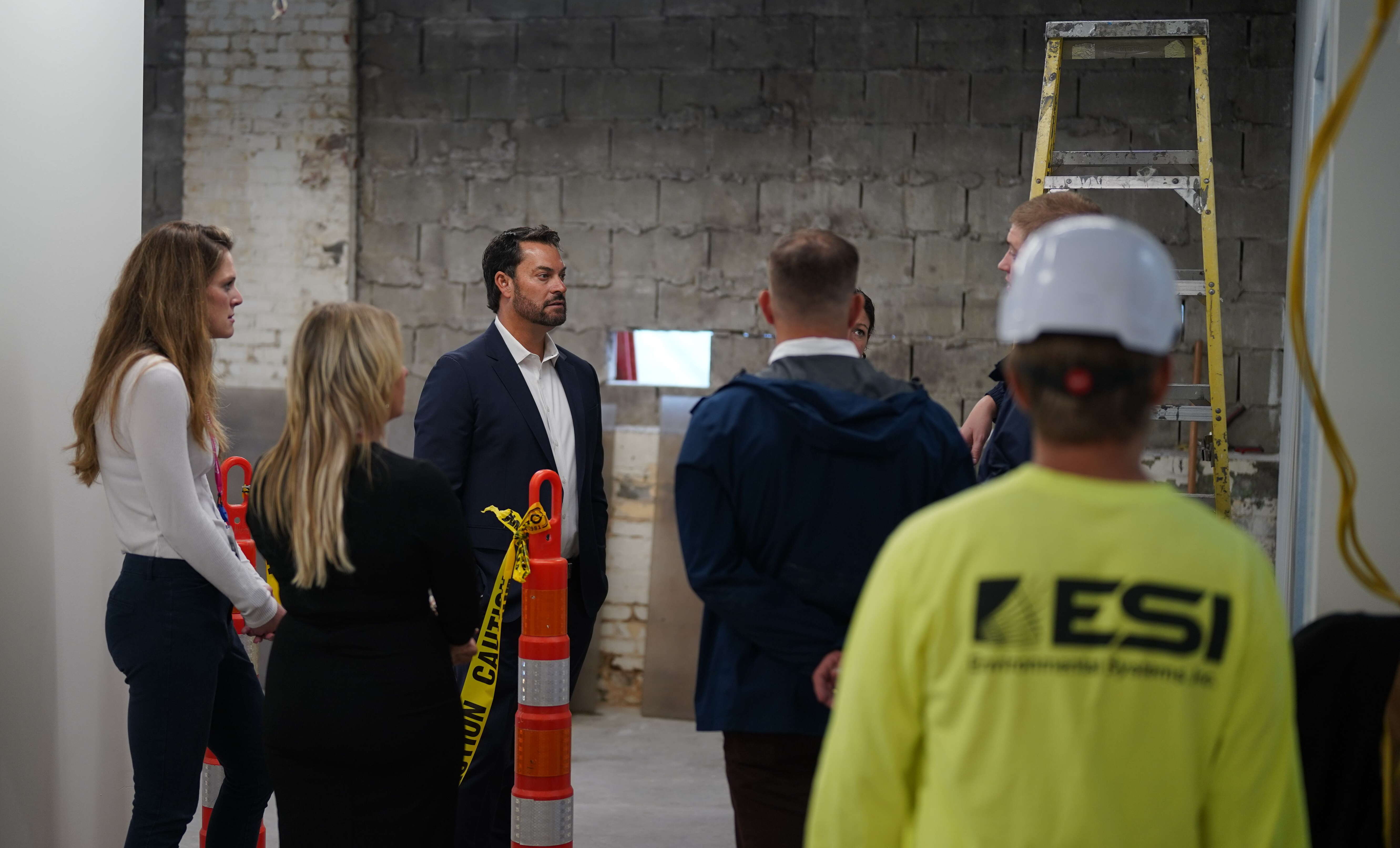 Group of people stand inside a building under renovation 