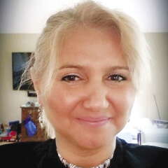 A woman with light hair smiles at the camera.