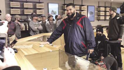 A man stands at the counter of a crowded dispensary.