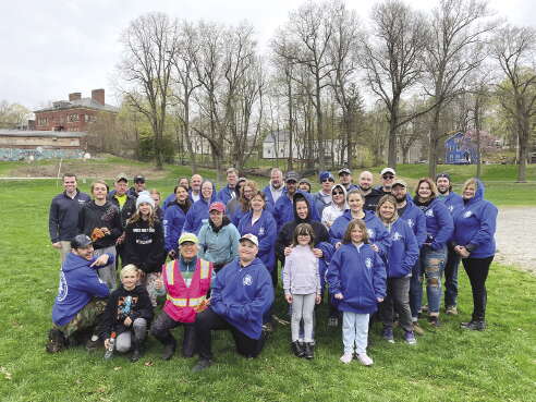 A group of people stand in a field for a photo