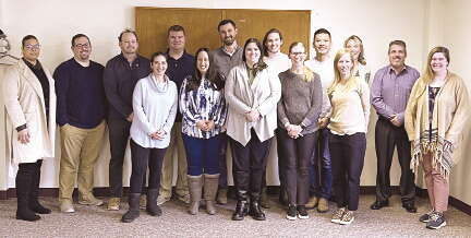 A group of young professionals stand in two rows