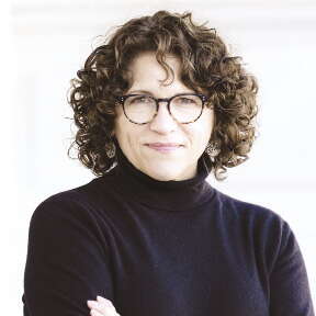 A woman in a turtleneck with glasses