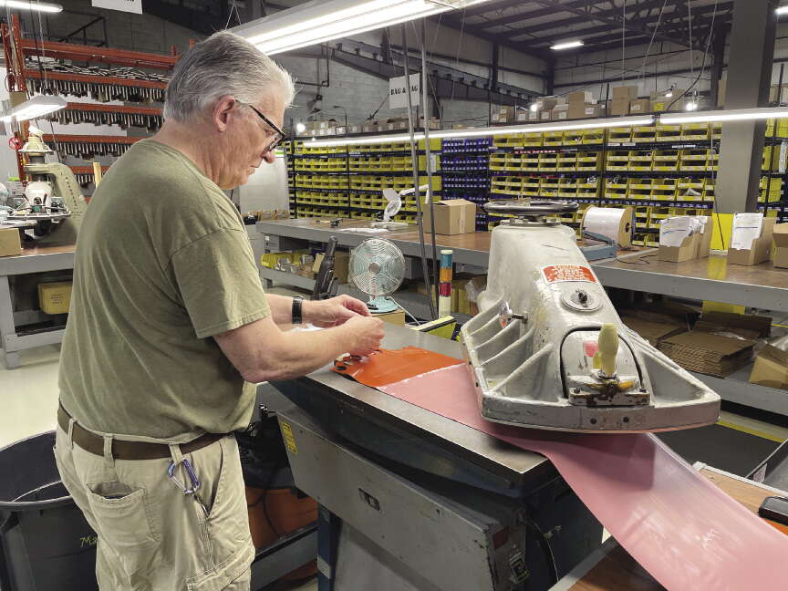 A man wearing a green shirt works in a warehouse.