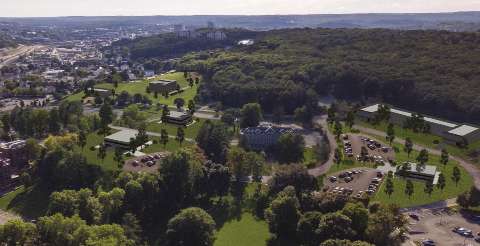 An aerial photo of the Reactory site with trees, buildings, parking, and construction 