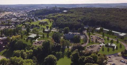 An aerial photo of the Reactory site with trees, buildings, parking, and construction 