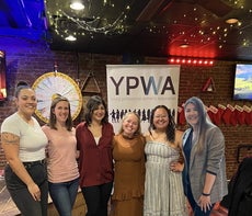 Five members of the YPWA board stand together at an event, while a sixth member has been edited into the photo.