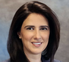 A woman with shoulder length brown hair smiles for the camera.