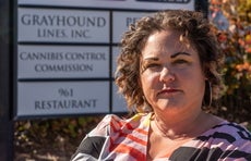 A woman stands in front of a sign 