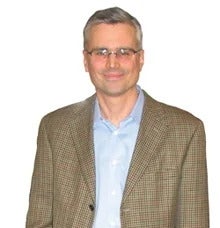 Man with glasses in beige checkered suit