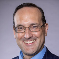 A headshot of a man wearing glasses