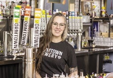 A woman stands behind a bar