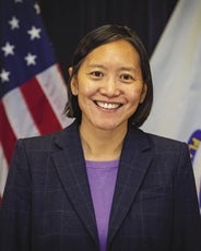 Yvonne Hao, smiling with U.S. flag in the background