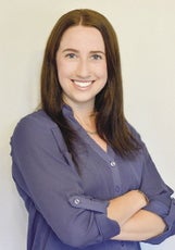 A woman with brown hair wears a blue shirt