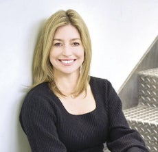 A woman with blonde hair smiles at the camera