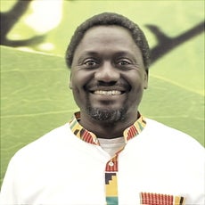 A man wears a white shirt with a patterned collar.
