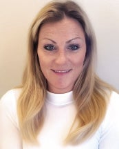 a headshot of a woman with blonde hair wearing a white sweater