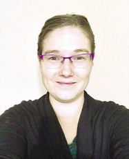 A woman wearing glasses and a black cardigan