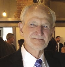 a portrait photo of a man in a suit