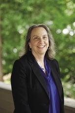 A photo of a woman in a blue blouse and black blazer.