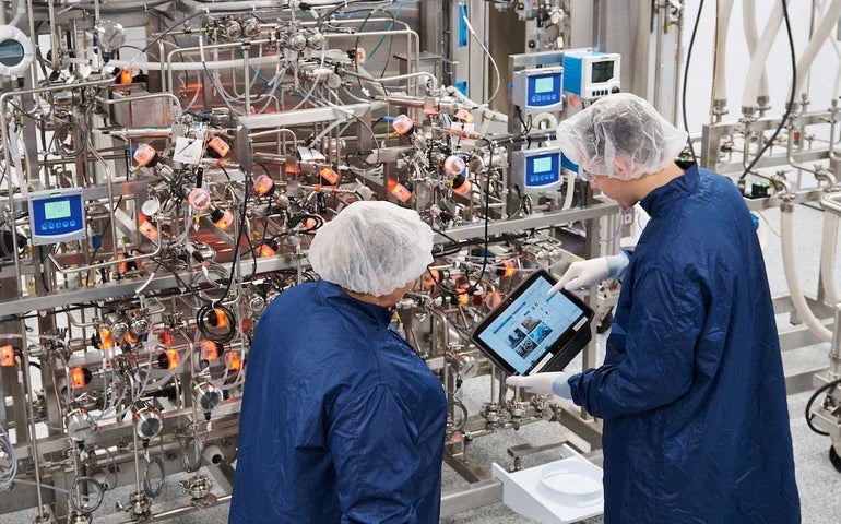 Employees at Sanofi's new Framingham facility, which is the company's first digitally born facility, examine instruments in the ab.  