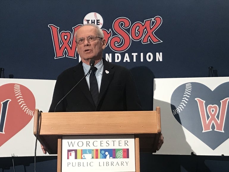 A man in a suit at a podium speaking into a microphone