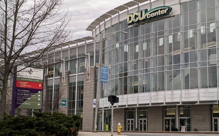 A large building behind an intersection with large glass windows.