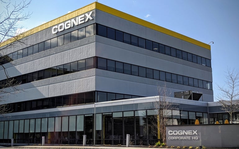 A grey building with yellow trim around the top and "COGNEX" lettered on the side