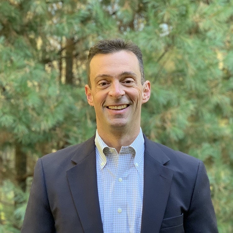 A smiling executive in a sports coat and button-down shirt