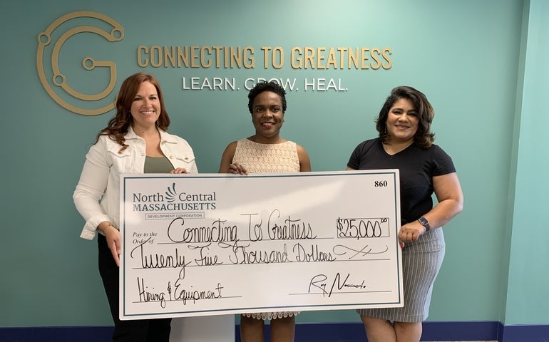 Connecting to Greatness receives the big check for its $25,000 loan.