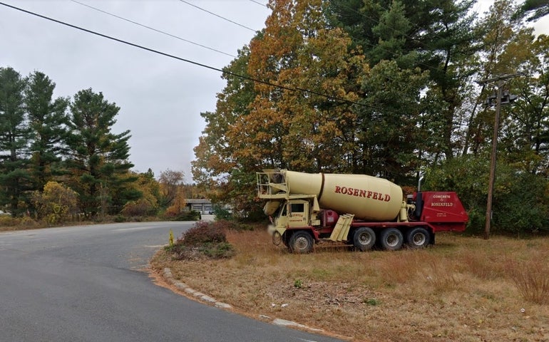 A cement truck at the entrance to an industrial property