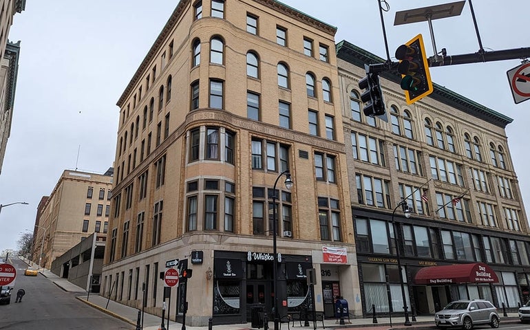 A corner building with limestone facade and rounded corner