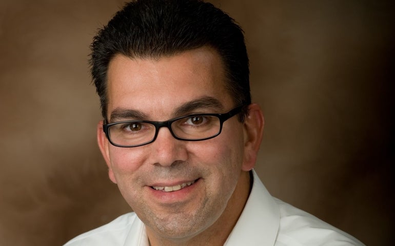 A man with glasses and a white button down shirt