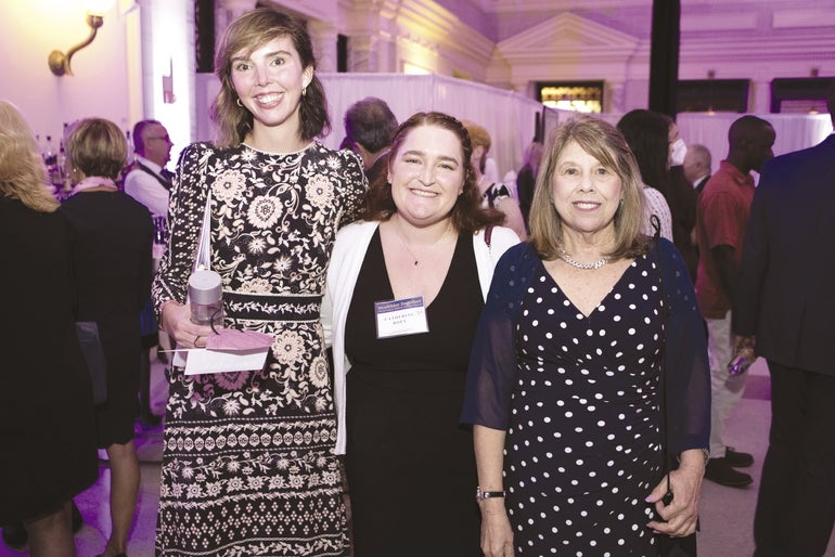Three smiling people standing together
