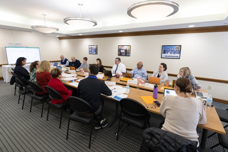 A group of people sitting at a large conference table.