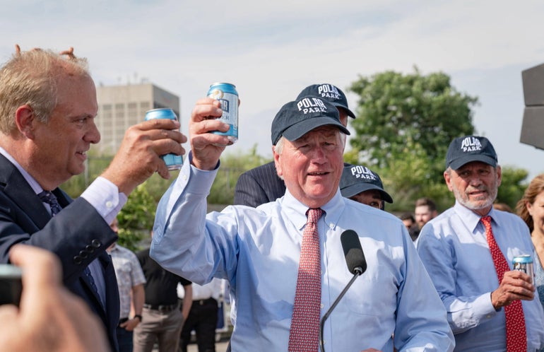 A group of men do a cheers with Polar seltzer on a sunny day in Worcester.