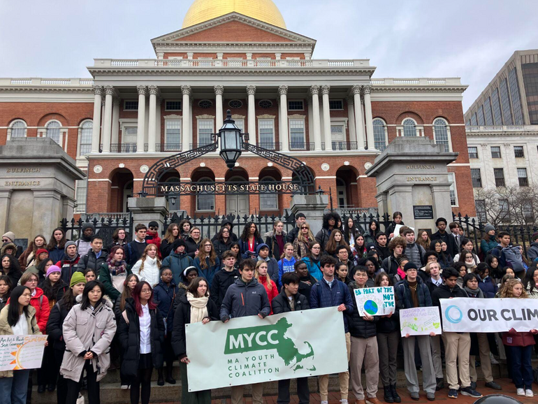 Young adults standing on steps in front of the state house
