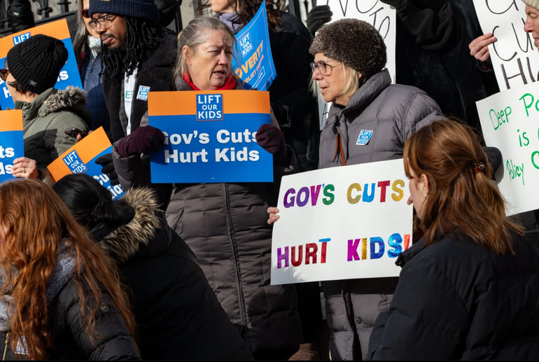 A group people stand with protest signs