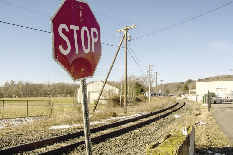 A stop sign in front of a railroad track